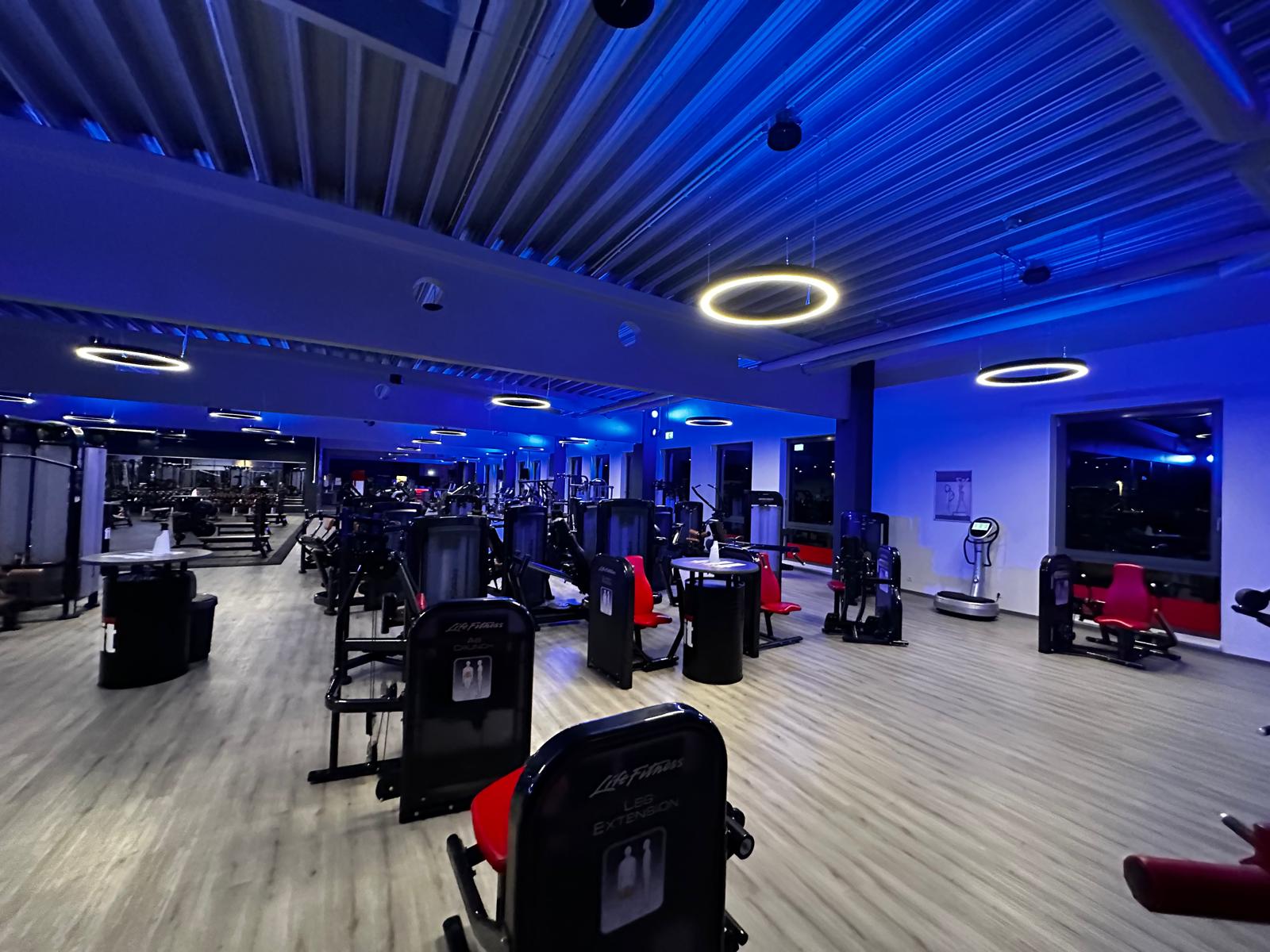 Showroom mit violettem Licht, Holzfußboden und Trainingsbereich