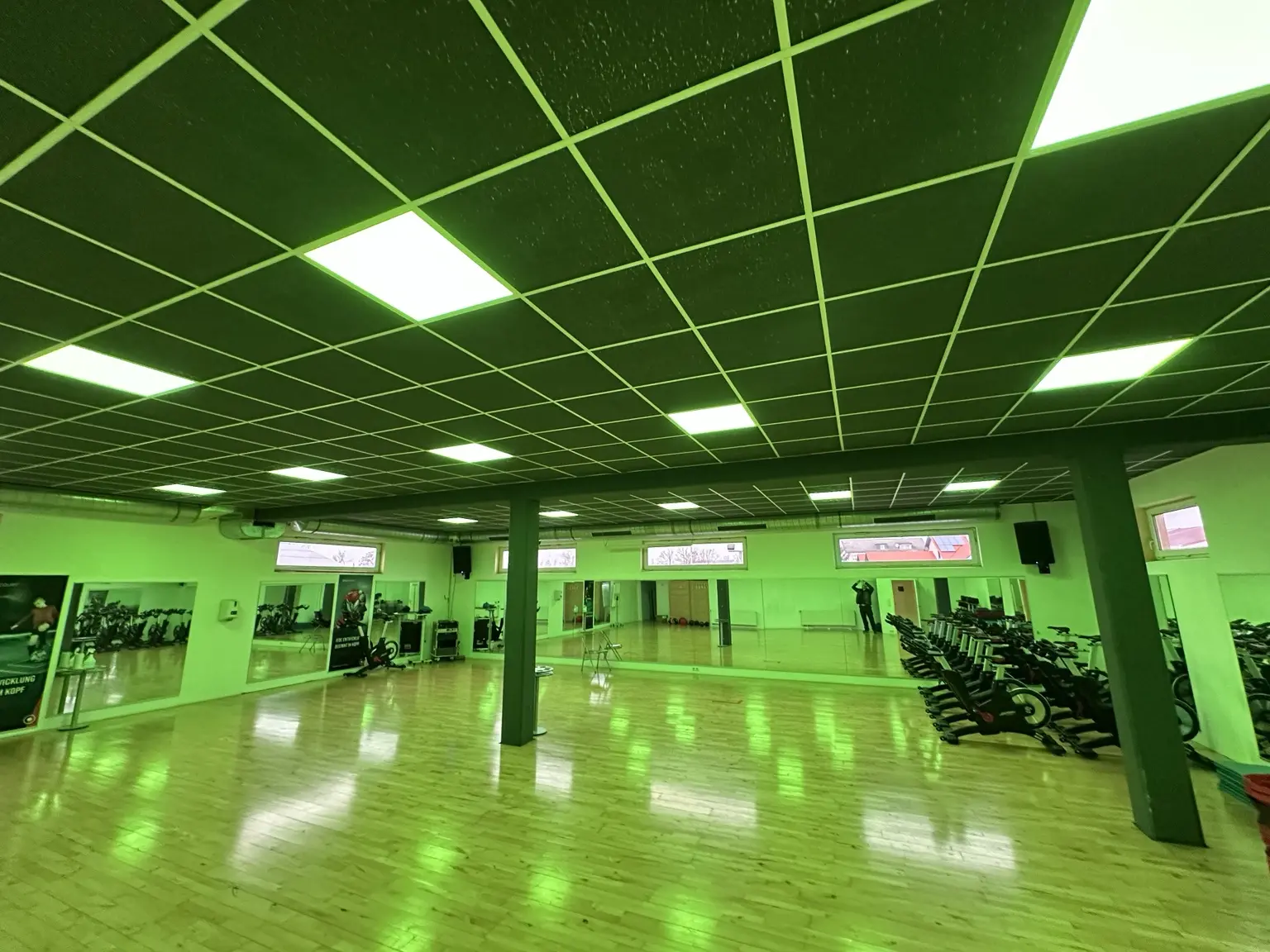 Fitnessfläche mit Kraftbereich, Ringlichtern und blauer Beleuchtung